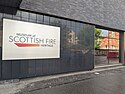 A white sign on a dark grey exterior wall which reads "Museum of Scottish Fire Heritage