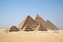 Three large pyramids in the desert, together with subsidiary pyramids and the remains of other structures