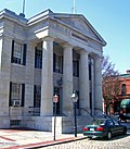 The front of a granite building, which has four columns supporting a triangular pediment.