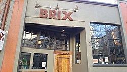 A classic, brown-themed, two-story building, with a sign reading "BRIX" at the top of the entrance