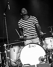 A drummer plays the drums on a stage.