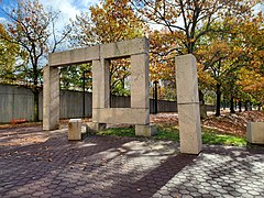 A sculpture of large granite blocks with pavers and trees