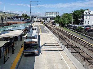 A bus at a bus station next to a railway station with a single platform