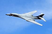 B-1B with its wings swept back doing a banked turn during a demonstration