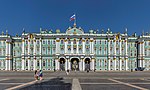 Baroque palace with green and gold facade and a Russian flag on the top