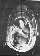 Photographie d'une femme japonaise travaillant dans la structure d'un avion en construction.