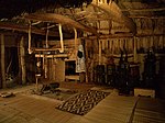 Elaborate interior entirely lined in thatch and matting, with central hearth