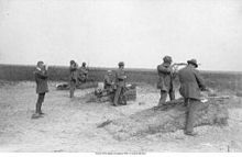 Photographie montrant les tireurs norvégiens avec leurs fusils dans le champ de tir, l'un étant en position de tirer debout.