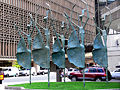 Un groupe de cinq statues de ballerines dans une rue de Denver.