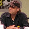 A seated man wearing a cap smiles as he looks into the distance. His hands are crossed. (from List of awards and nominations received by The Simpsons)