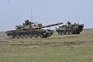 Tanc TR-85 (stânga) și blindat Stryker⁠(en)[traduceți] (dreapta) la Smârdan (2015)