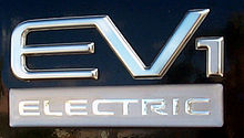 The badging of a car. The badging is silver, saying "EV1".