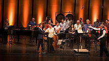 A close-up of entertainers on a stage sharing recognition for a performance