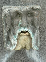 Detail of the fountain, located to the side of the church, with the representation of the god Oceanus, the symbol of Jublains