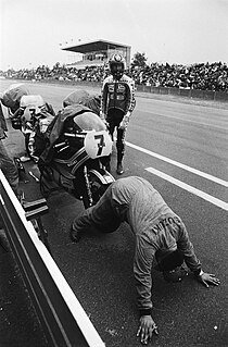 Geen menselijk fietsenrek, maar een monteur die de wieluitlijning van de Suzuki RG 500 van Barry Sheene controleert. De kleine spoilers op de kuip van de machine waren een idee van Barry zelf en maakten de motorfiets stabieler nadat het nieuwe, getrapte motorblok voor een andere gewichtsverdeling had gezorgd