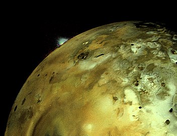 A volcanic eruption plume rises over the limb of Io.