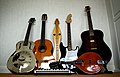 Different types of guitars (from left: resophonic, classical, electric and Western). There are also: a dulcimer in center and, placed horizontally, a MIDI keyboard and a mandolin