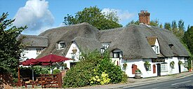 English pub names such as The Barley Mow (like this pub at Clifton Hampden) allude to the use of barley to make the beer available inside.[93]