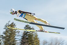 Un homme volant comme un oiseau ses skis comme des ailes.