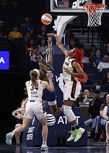 Two Indiana Fever players trying to get a ball with a Minnesota Lynx player among them