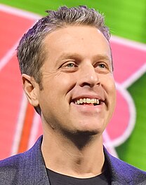 A man with brown hair smiling to the right.