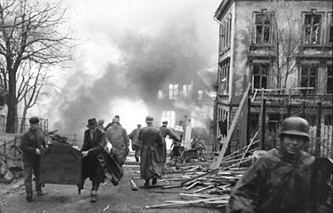 English: Soldiers and civilians carrying possessions away from burning buildings after the Voorbode explosion in April 1944.
