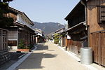 Two storied wooden houses next lining a street.