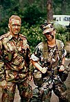 Royal Bermuda Regiment NCO in No. 9 dress with shirt worn out, and a US Navy NAS Bermuda (female) Corspman.