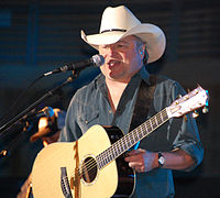 Country music singer Mark Chesnutt singing and strumming a guitar.