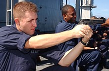 Electronics Technician 3rd Class Jeremy Aragon practices drawing and firing the M9 Beretta service pistol during force protection training aboard USS Blue Ridge.