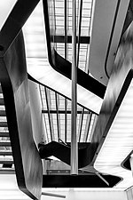 Photographie en noir et blanc. Vue d'un escalier en contre-plongée.