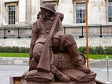 A brown sculpture of a slumping First World War infantryman