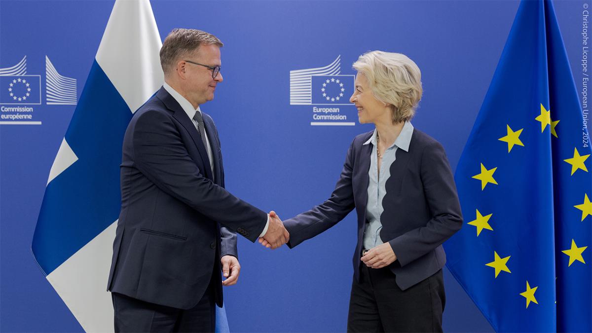 Kuvassa pääministeri Petteri Orpo ja komission puheenjohtaja Ursula von der Leyen Suomen ja EU:n lippujen edessä.