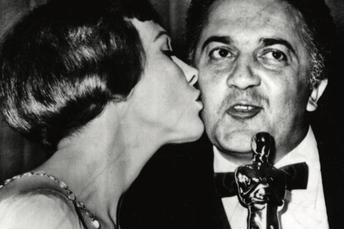 Fellini gets a kiss from Julie Andrews after winning an Oscar