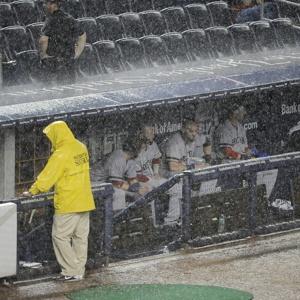 REIGN MEN: The Red Sox sit in the dugout during a rain delay in the sixth inning, the third of the night which eventually forced umpires to call the game.