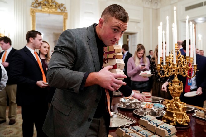 A Clemson player carries fast food hamburgers.