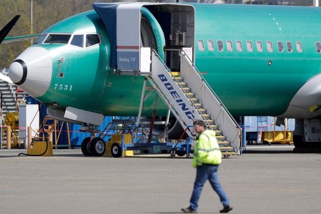 A worker walks past a Boeing 737 Max 8 airplane