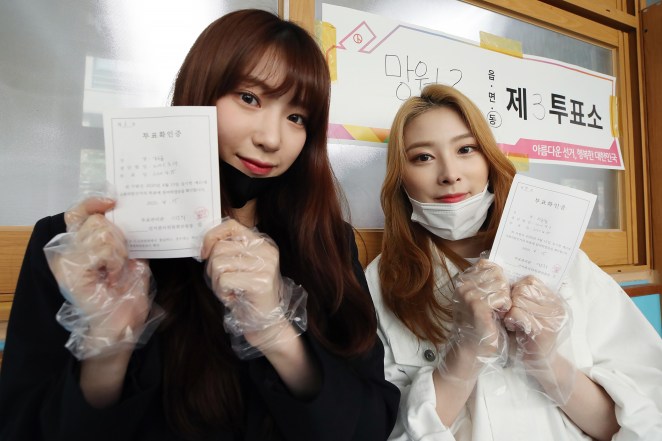 Soo Yoon (L) and Yoon Kyung (R), members of South Korean girl group Rocket Punch, pose for a photo after casting their ballots