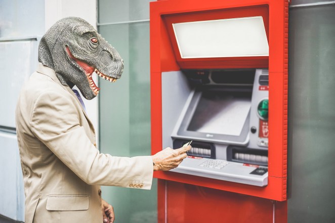 man in dinosaur costume going to ATM