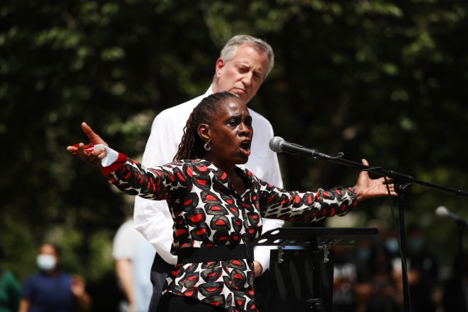 New York Mayor Bill de Blasio listens as his wife, First Lady Chirlane McCray, speaks to an estimated 10,000 people as they gather in Brooklyns Cadman Plaza Park for a memorial service for George Floyd.