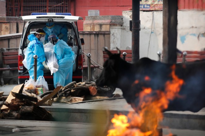 People carry out the body of their relative who died of coronavirus from an ambulance for cremation in New Delhi, India.