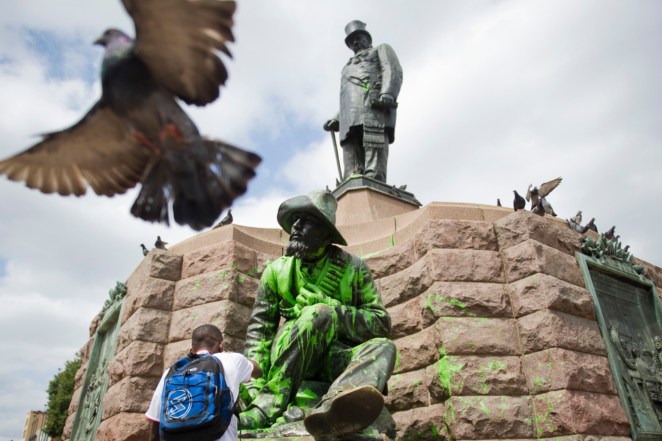 A statue splashed with green paint, sits beneath a statue of Paul Kruger, top, who was president of the Republic of South Africa from 1883 to 1900, after being vandalized on Pretoria's Church Square, South Africa.