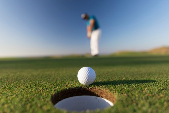 Golf ball entering the hole after successful stroke - Close up - Links Golf