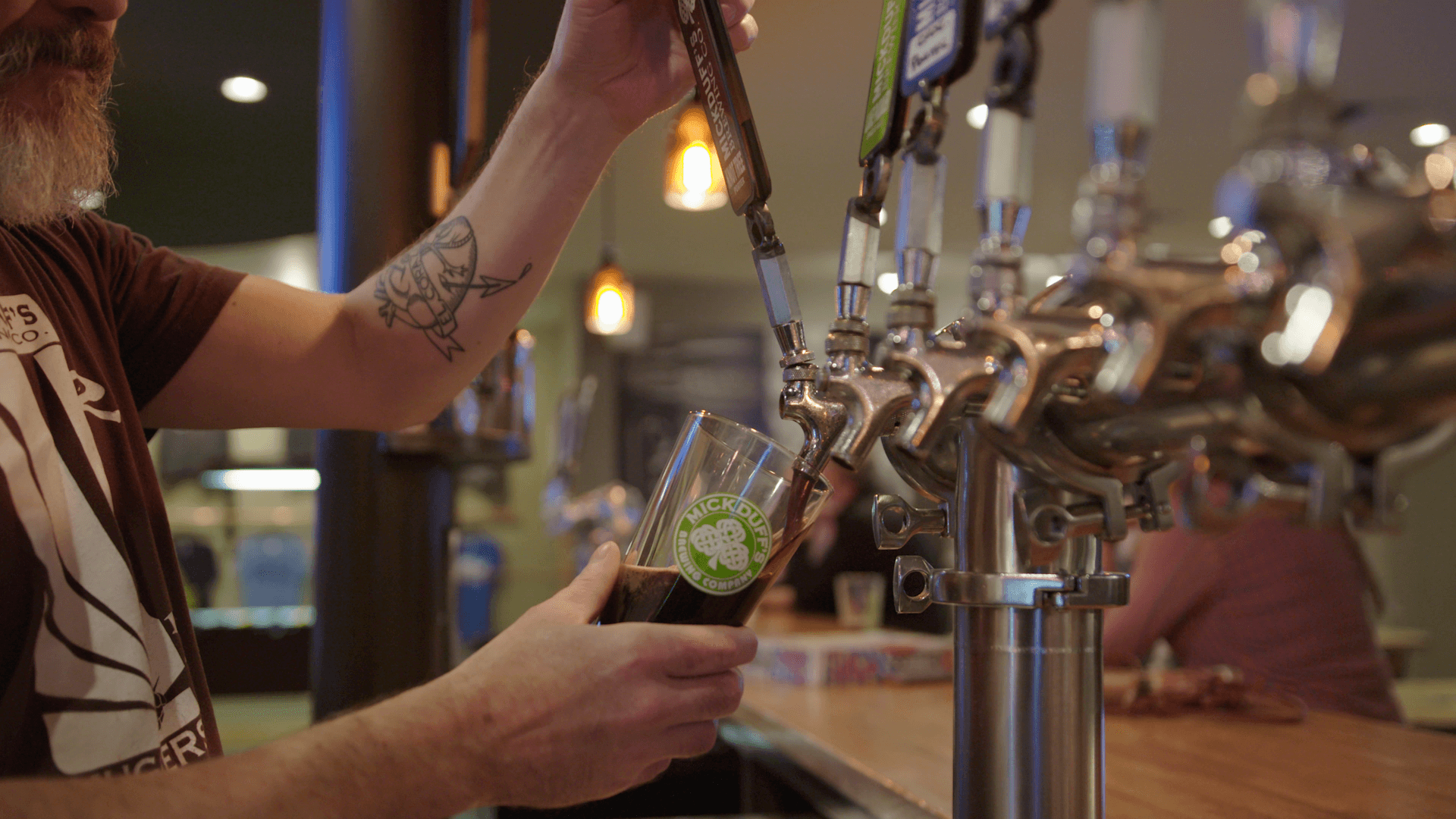 A man pouring beer into a pint glass at MickDuff's Brewing Company.