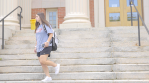 A Worcester State student walking down stairs of a building on campus