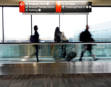Travelers walk to their gates at the Philadelphia International Airport