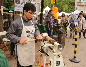 A crafter uses a machine at Crafters Village