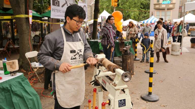 A crafter uses a machine at Crafters Village