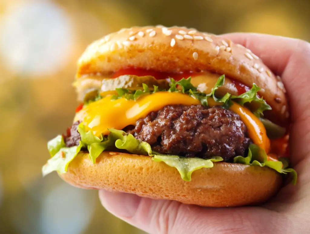 Hand holding a warm homemade hamburger in outdoors Best burger in Florida