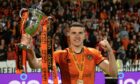 Dundee United defender Ross Graham with the Championship trophy. Image: SNS